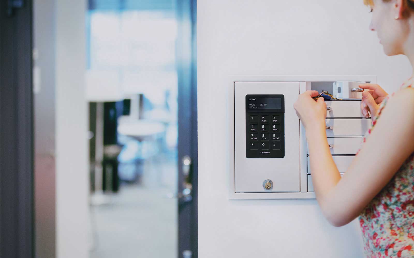 femme qui prend des clés dans une armoire à clés